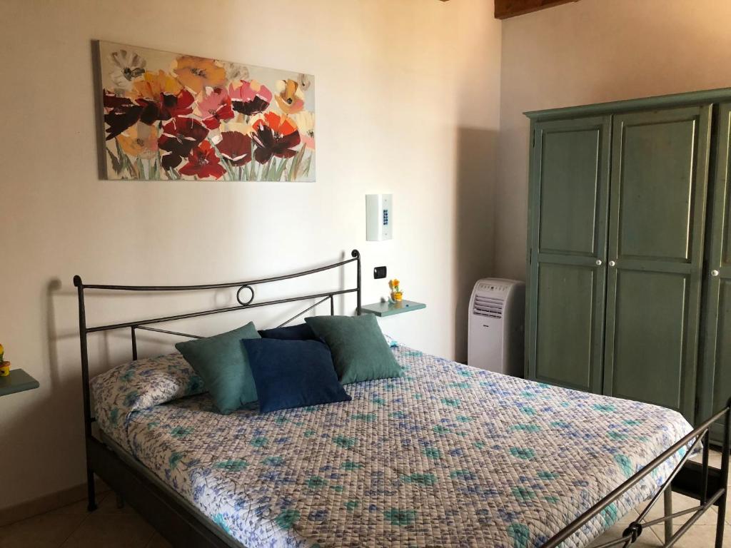 una camera da letto con un letto e un dipinto sul muro di Villetta fronte mare ad Arbus
