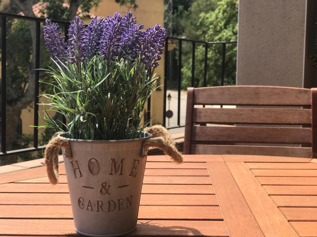 a vase with purple flowers sitting on a table at Lets Holidays apartment terrace La Guardia in Tossa de Mar