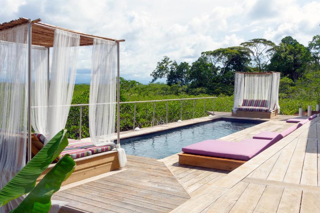 una piscina con sedie a sdraio e una terrazza con vista di Villa F&B a Bocas del Toro