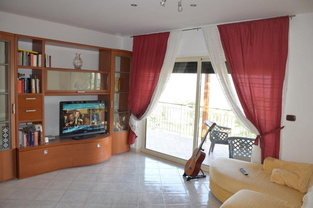 uma sala de estar com um sofá, uma televisão e uma janela em Luna Apartaments em Badolato