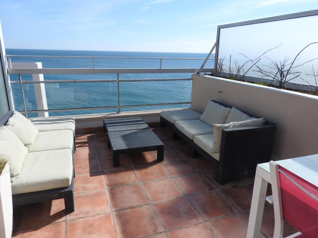 balcón con sofás, mesa y vistas al océano en Appartement Vue Mer - Sète en Sète