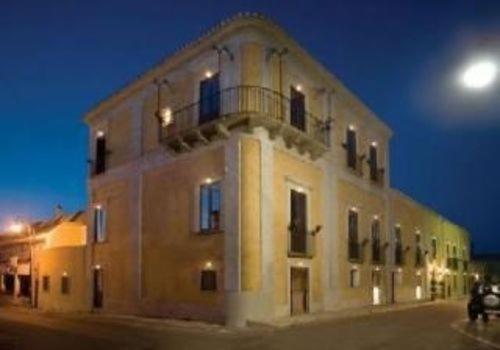 un bâtiment avec un balcon en haut le soir dans l'établissement Palazzo Marzano, à Briatico