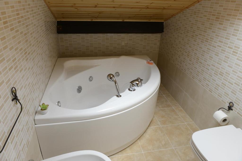 El baño incluye bañera blanca y aseo. en B&B San Leonardo, en Mascali