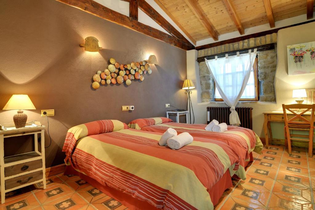 1 dormitorio con 2 camas y TV en Alojamiento Rural La Cañada, en Murillo el Fruto