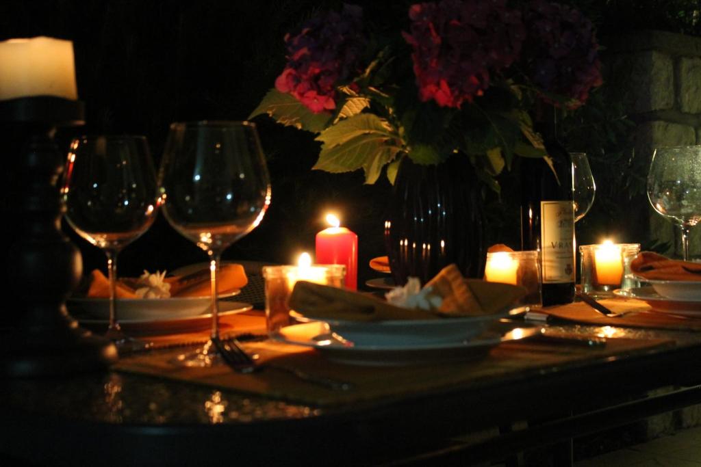 a table with wine glasses and a candle and flowers at Apartments 101 in Kotor