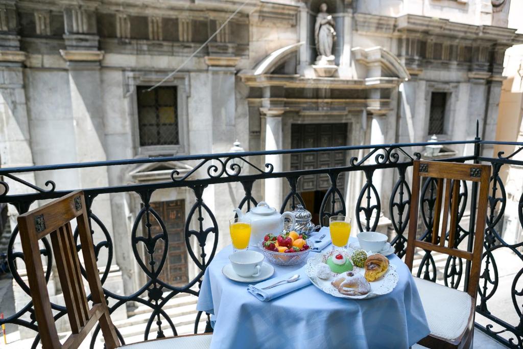 een tafel met eten en drinken op een balkon bij B&B Santa Caterina in Palermo