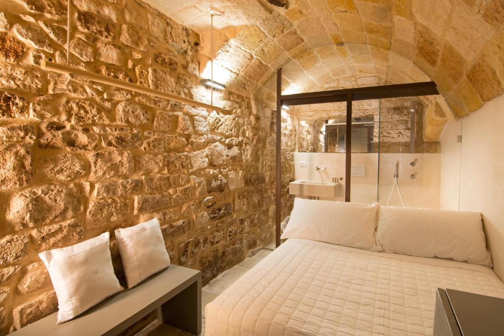 a bedroom with a bed in a brick wall at Dimora Talenti in Polignano a Mare