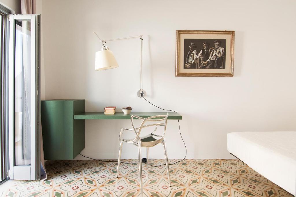 a desk in a bedroom with a bed and a chair at Dimora Talenti in Polignano a Mare