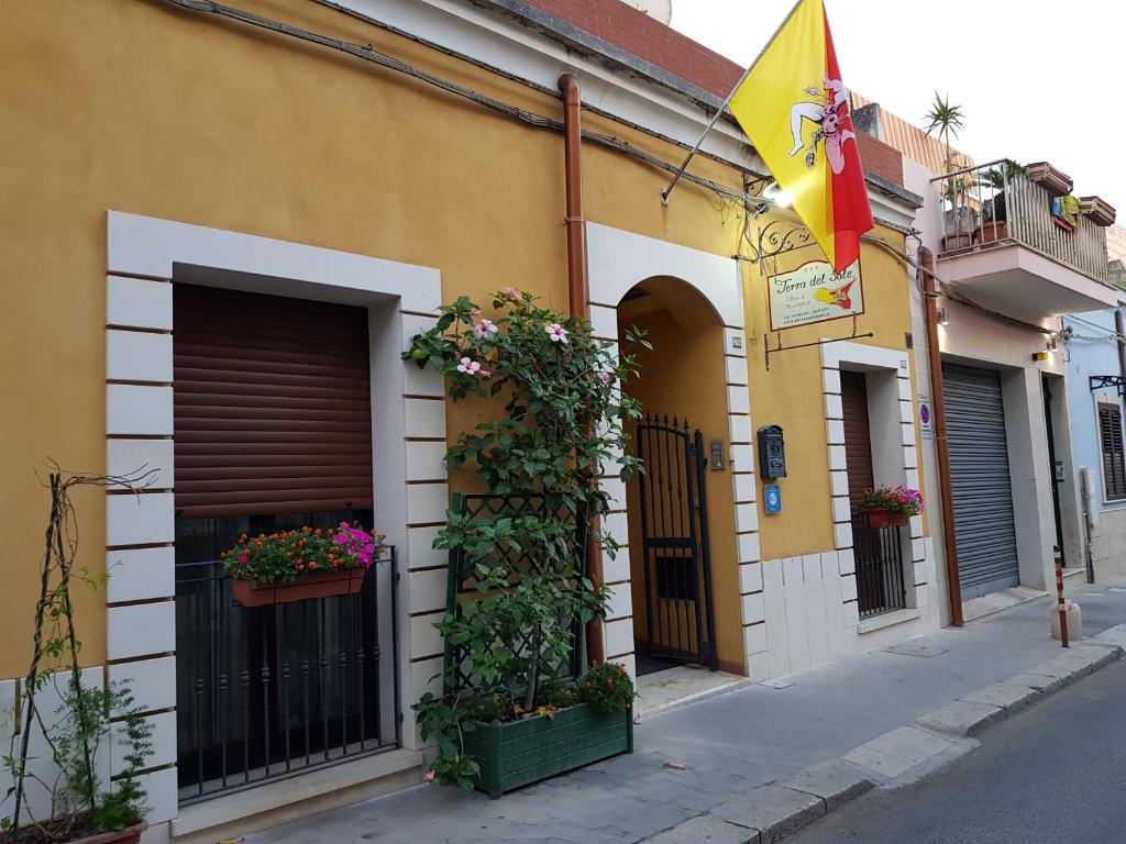 un bâtiment avec des fleurs et un drapeau dans une rue dans l'établissement Terra del Sole Vittoria, à Vittoria