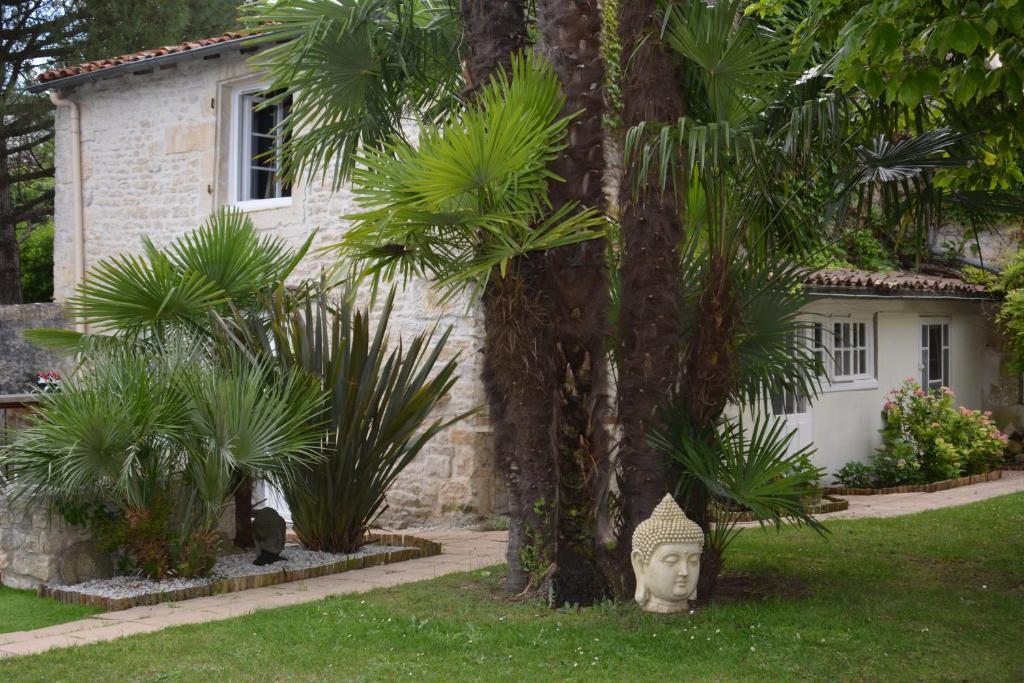 a garden with a statue in front of a house at Le Petit bois in Niort