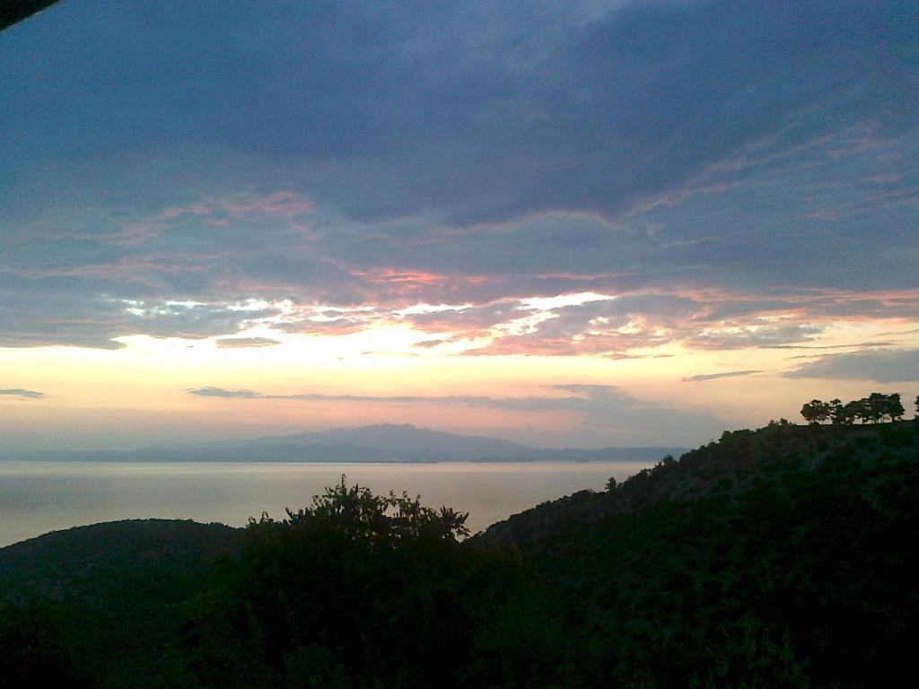 a view of the ocean at sunset from a mountain at Sotiros Sunset House in Skala Sotiros