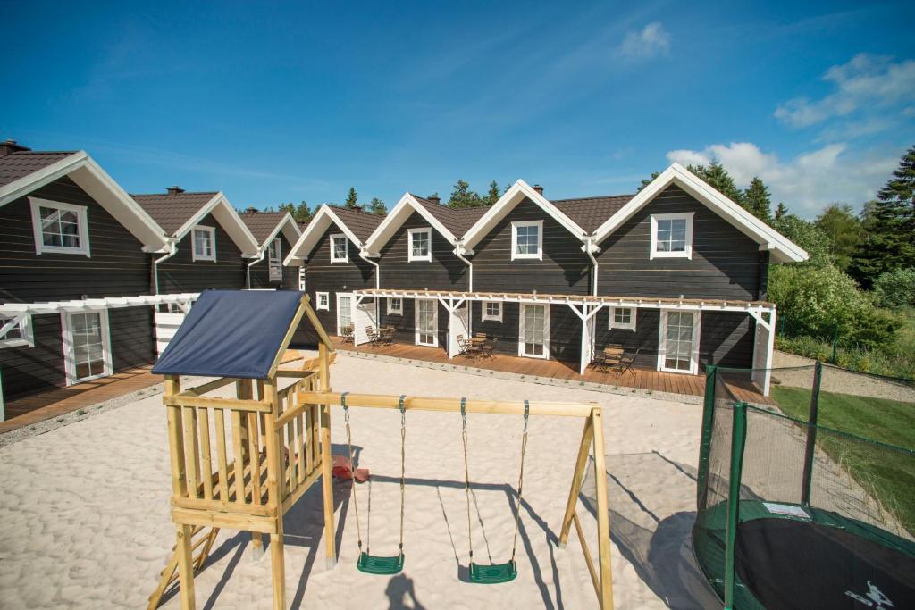 un parque infantil frente a una fila de casas en Bla Marine Domki nad Morzem en Grzybowo