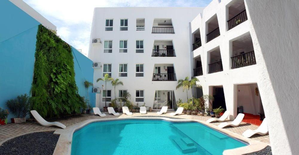 a swimming pool in front of a building at Hotel Berny in Isla Mujeres