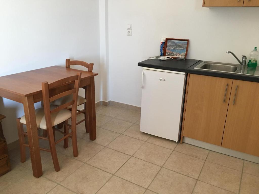 a kitchen with a wooden table and a sink at Eugenia travasarou sea view appartments in Diakofti