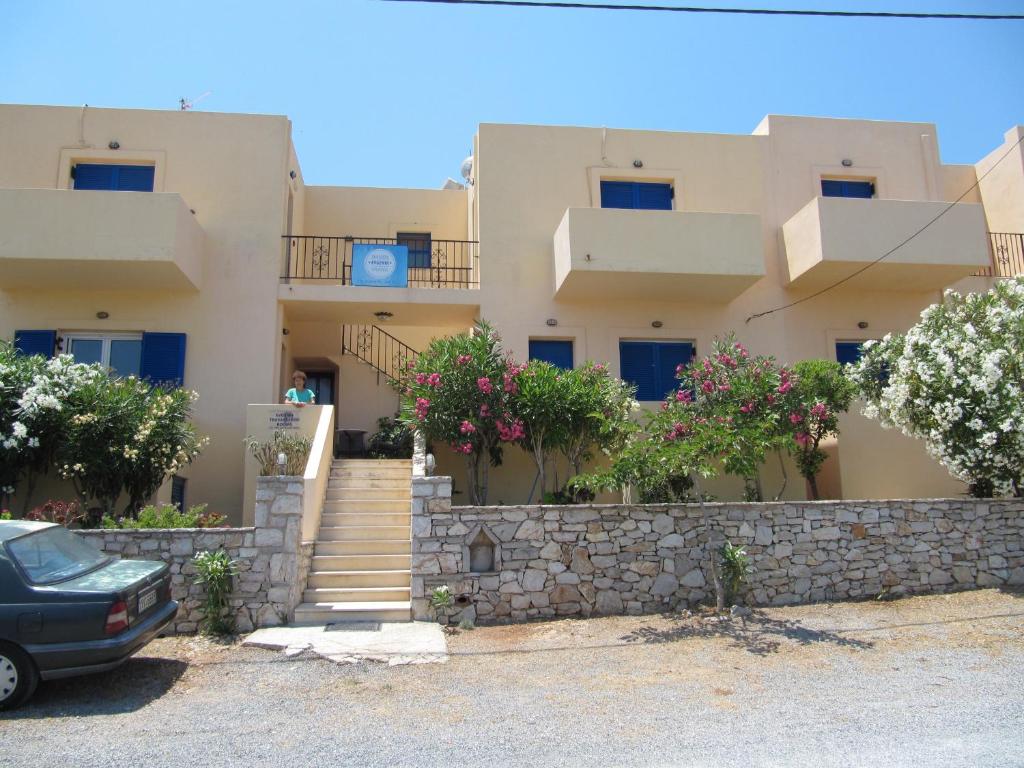 a house with stairs and flowers in front of it at Eugenia travasarou sea view appartments in Diakofti