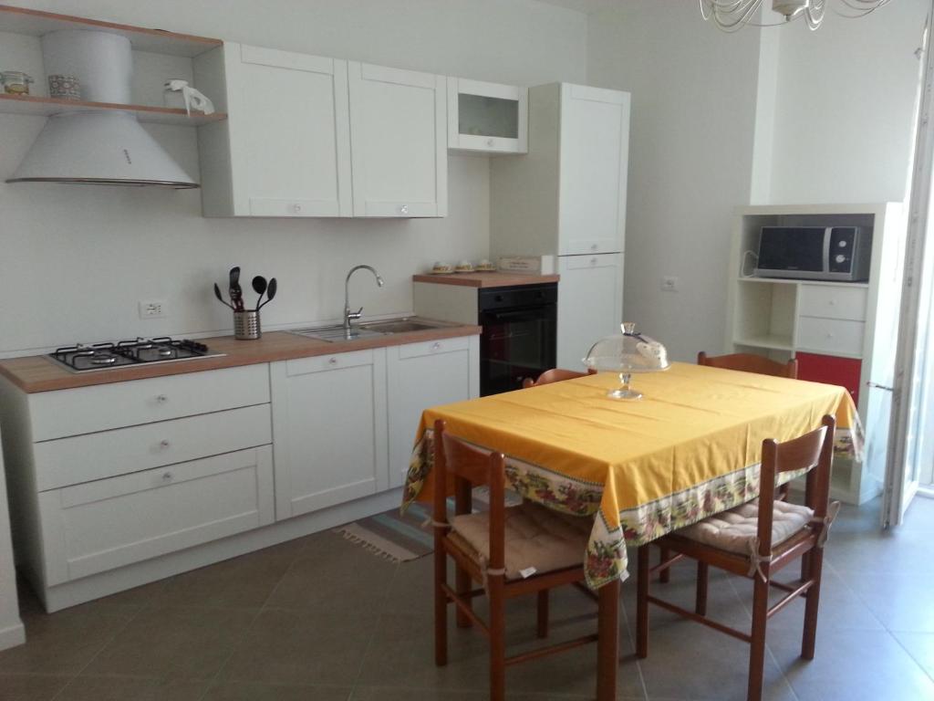 a kitchen with a table with a yellow table cloth on it at NUOVO BILOCALE IN VIA LAGOMAGGIO, 31 in Rimini
