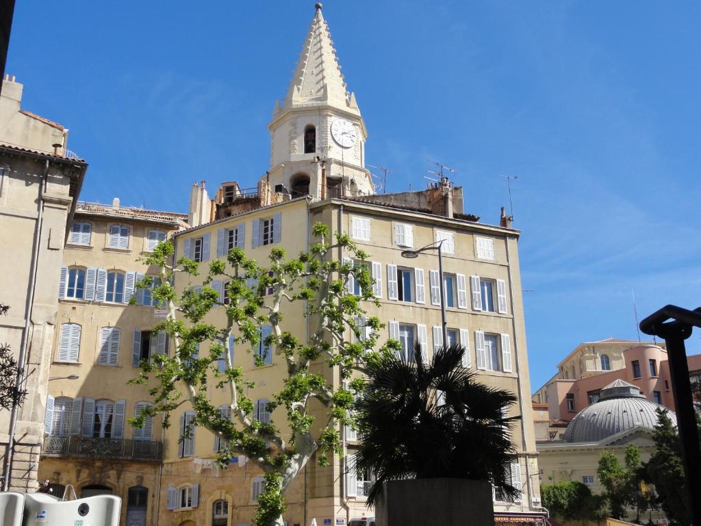 un bâtiment avec une tour d'horloge au sommet dans l'établissement La Maison des Augustines, à Marseille