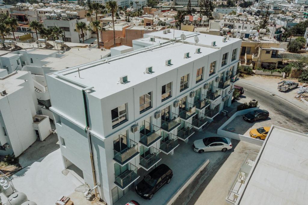 an aerial view of a white building with a parking lot at River View Boutique Apts in Ayia Napa