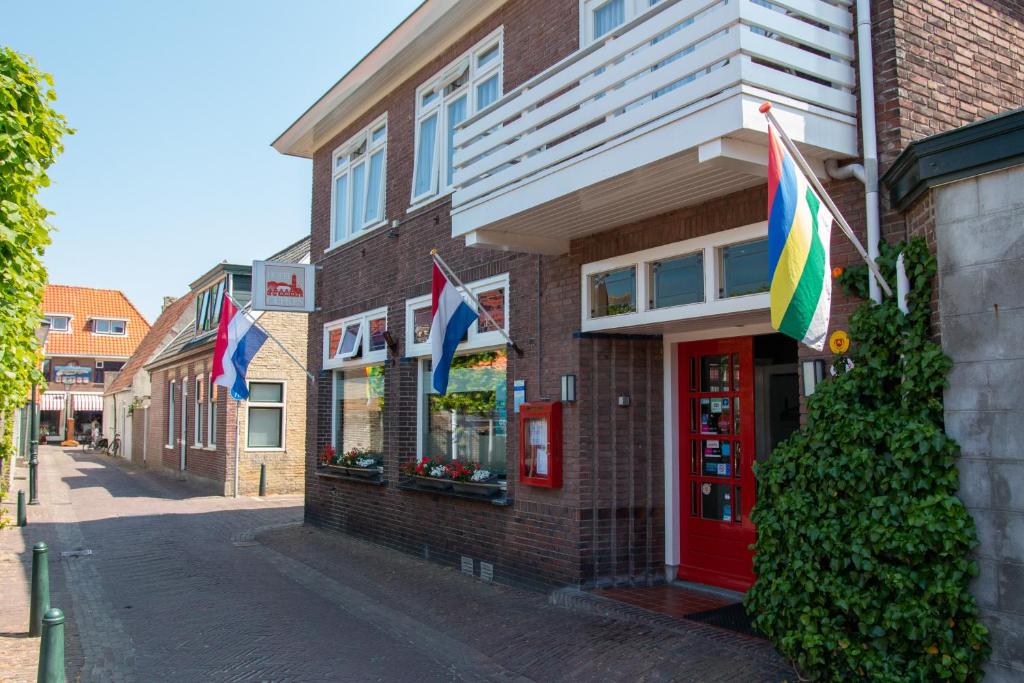 een gebouw met vlaggen aan de straatkant bij Hotel Oepkes in West-Terschelling