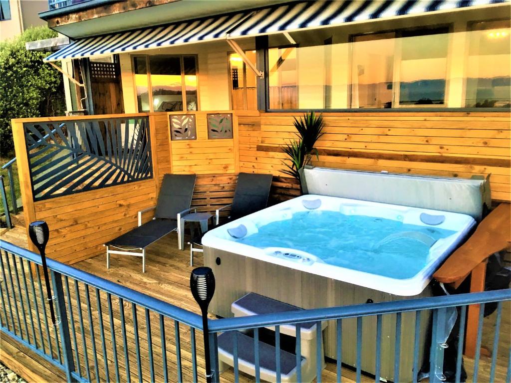 uma banheira de hidromassagem no deque de uma casa em Twin Peaks Villa em Nelson