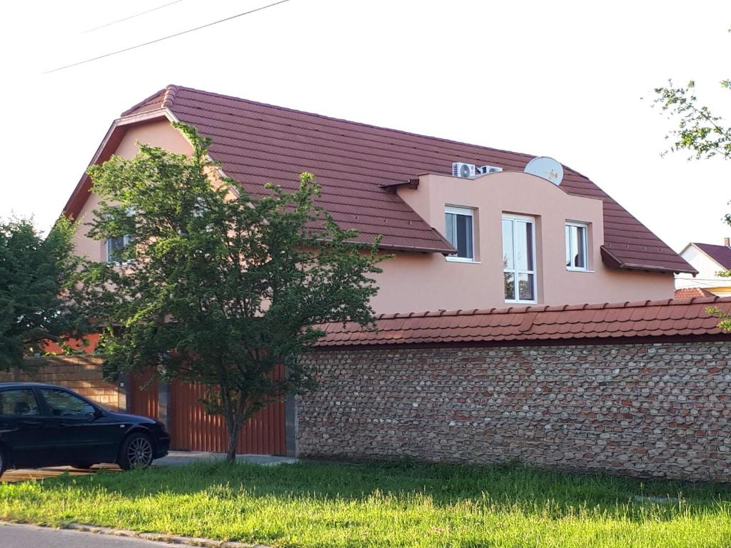 a house with a car parked in front of it at Sunshine Apartment in Hajdúszoboszló