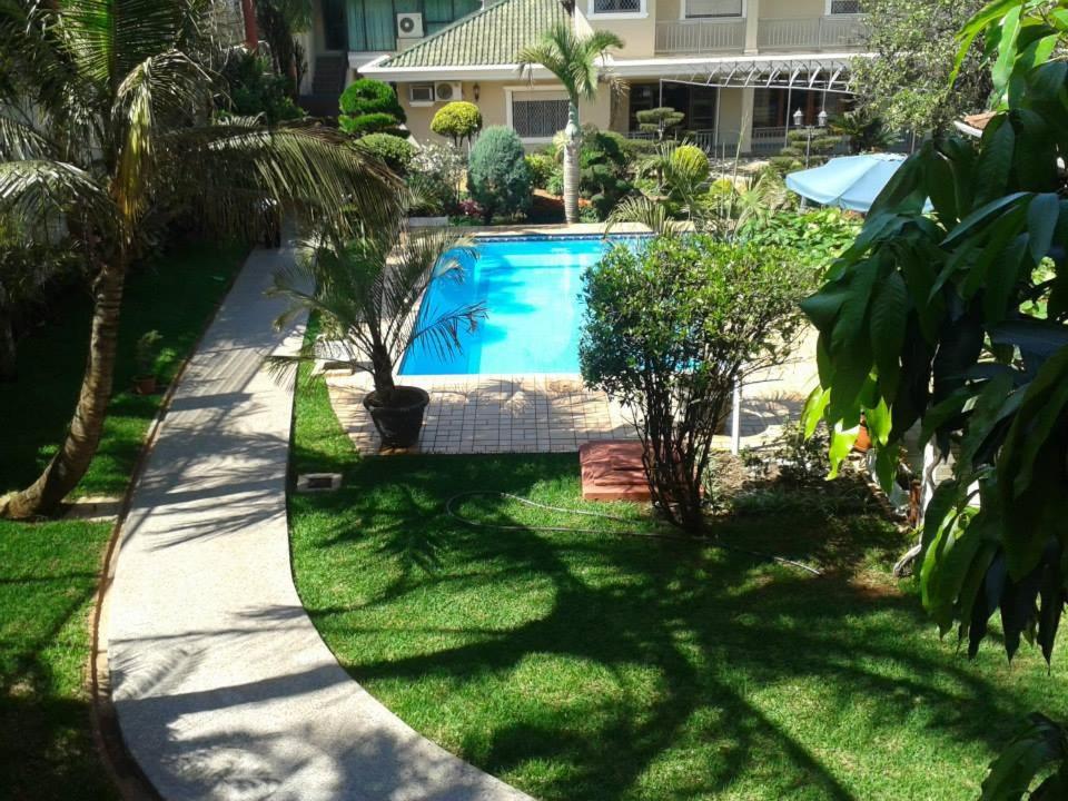 einen Pool in einem Garten mit Gras und Bäumen in der Unterkunft Hotel Arthur Shambala in Encarnación