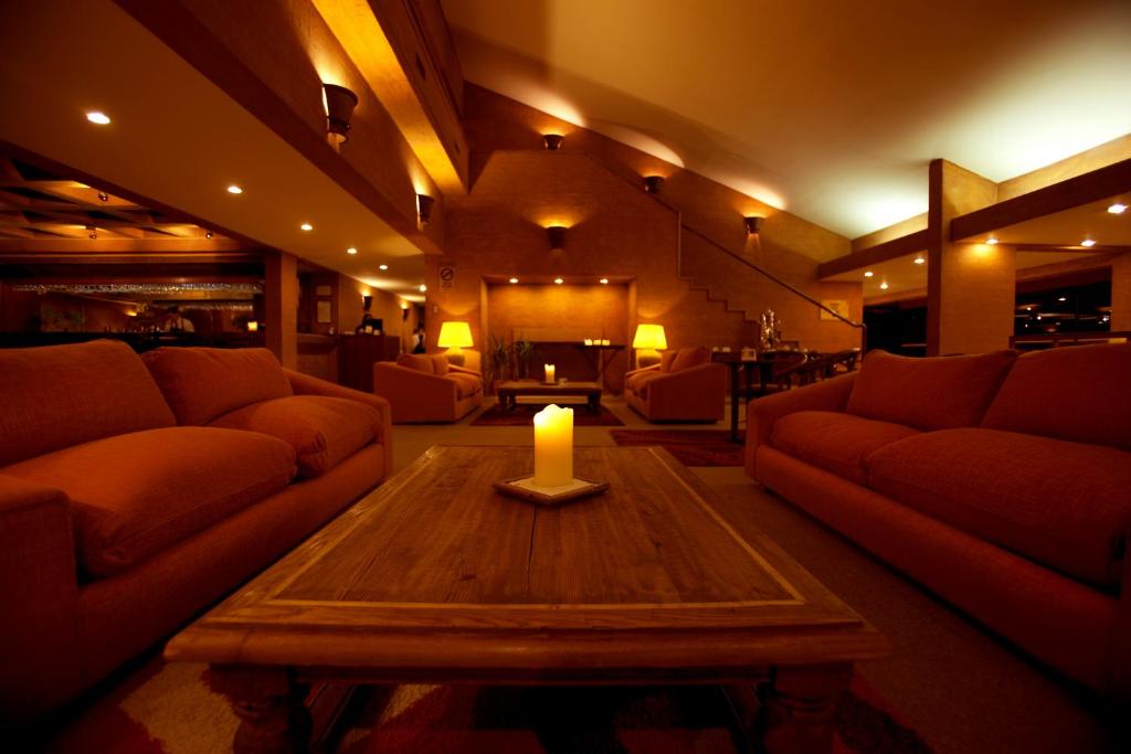 a living room with couches and a candle on a table at Park Hotel Calama in Calama