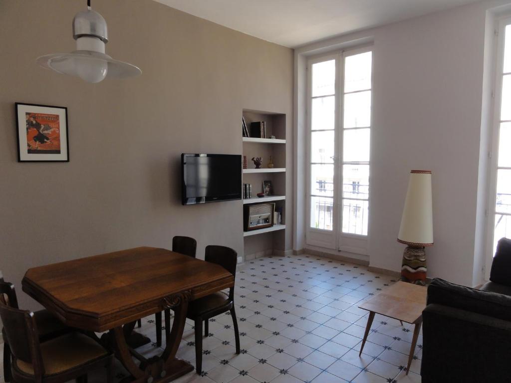 - un salon avec une table et une télévision dans l'établissement La MAISON de l'OPERA, à Marseille