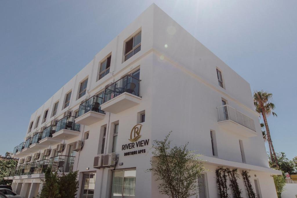 a white building with a sign on it at River View Boutique Apts in Ayia Napa