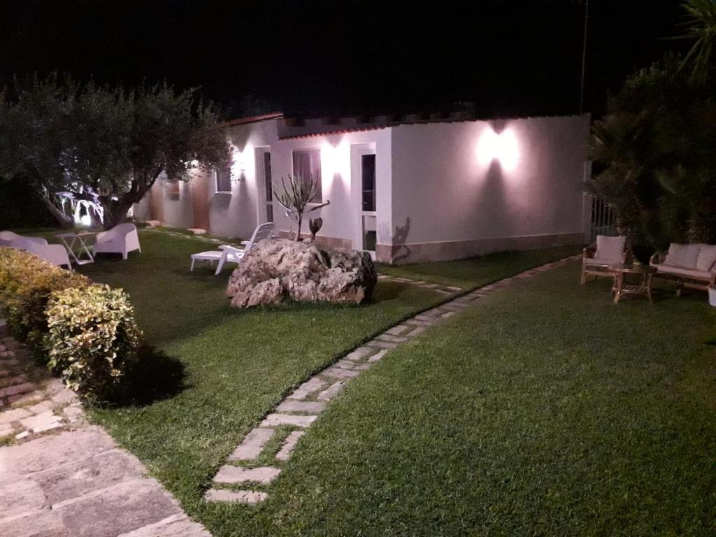 een tuin met een huis 's nachts met verlichting bij La casetta di viale Paradiso in Pachino