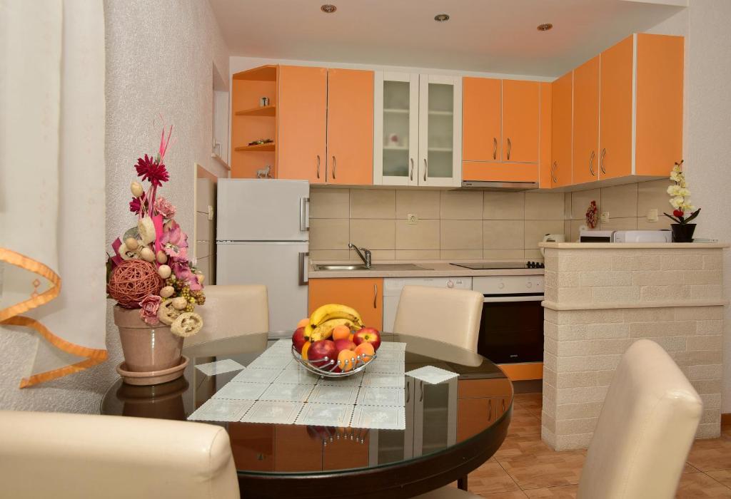 a kitchen with a table with a bowl of fruit on it at Apartment Markus in Makarska