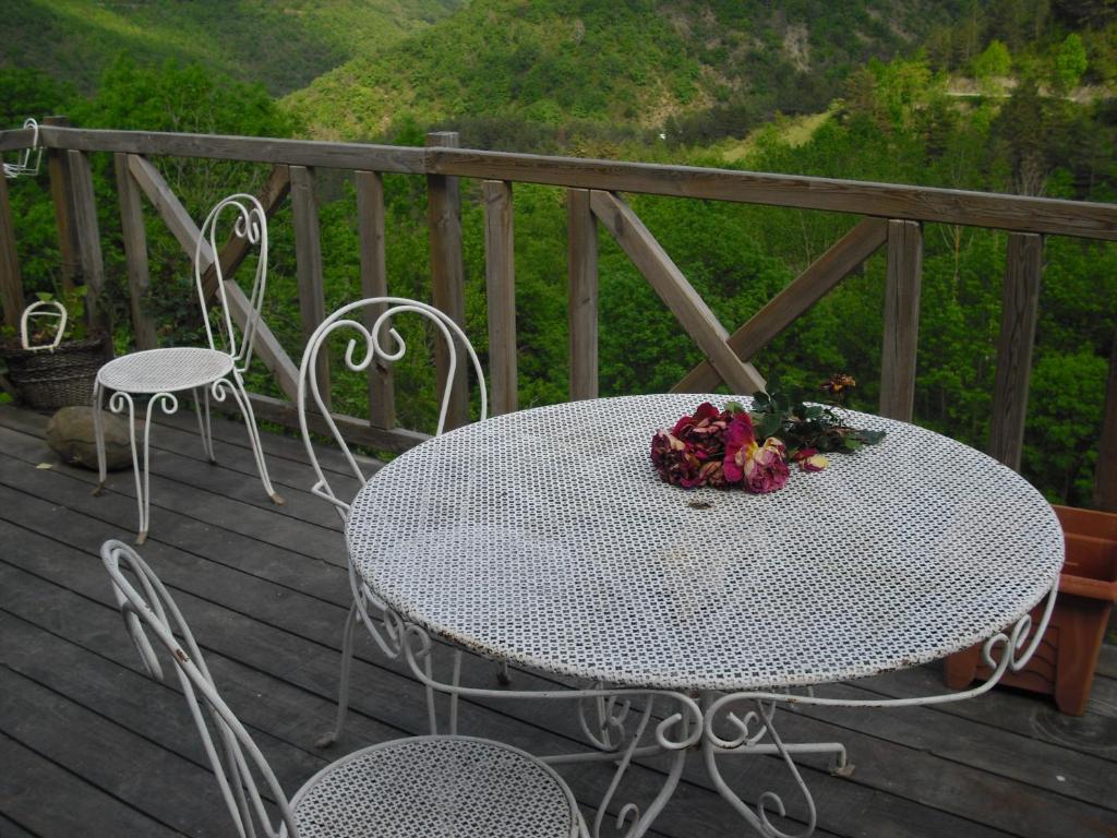 a white table and chairs on a wooden deck at Chambres D'Hôtes Les Terrasses de Cailla in Cailla