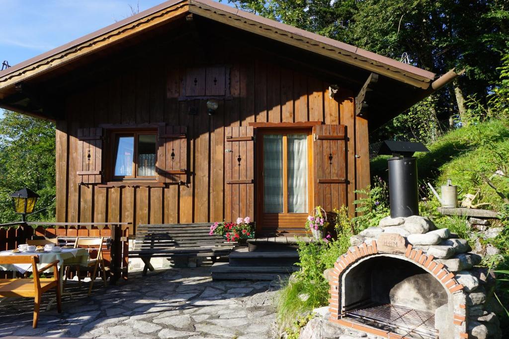 a small wooden cabin with a fireplace in a yard at Chalet Katrin in Sankt Koloman