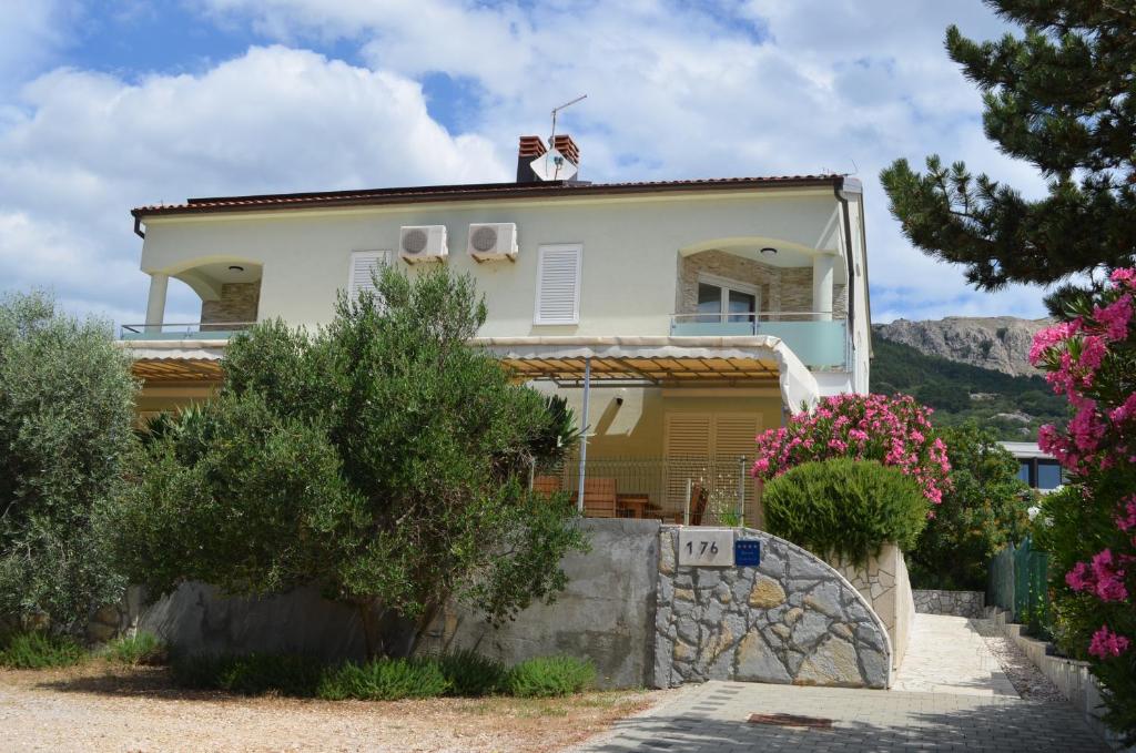 a house with a dog on the top of it at Apartments Buljan in Baška