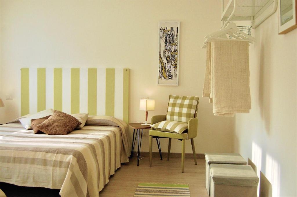 a bedroom with a bed and a chair and a table at Gardaselle Holiday Rooms in Cavalcaselle