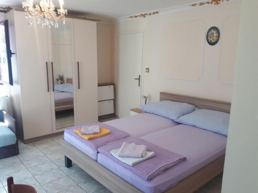 een slaapkamer met 2 bedden en een spiegel bij Apartments and rooms Makaj - 80 m from the beach in Basina