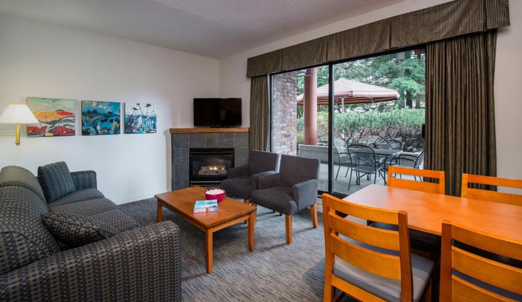 a living room with a table and a living room with a couch at Whistler Village Inn & Suites in Whistler