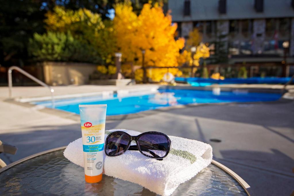 a pair of sunglasses and a bottle of sunscreen on a table at Whistler Village Inn & Suites in Whistler