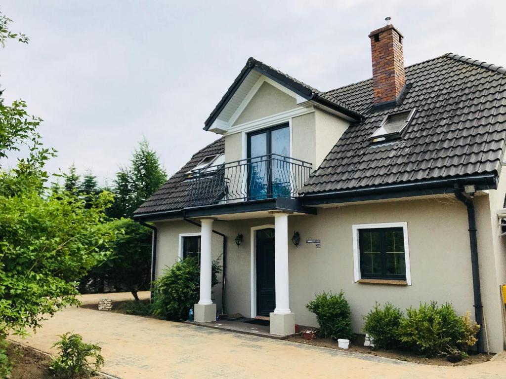 a white house with a black roof at Rezydencja Zofia in Sianów