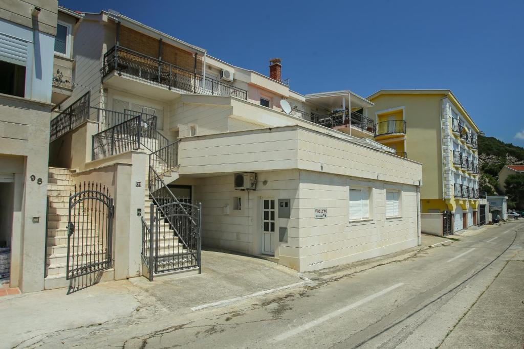 a building with a gate on the side of a street at Guesthouse Lamia in Neum