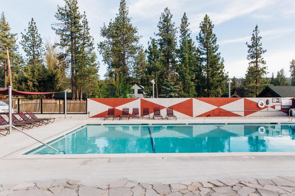 a swimming pool with trees in the background at Noon Lodge in Big Bear Lake