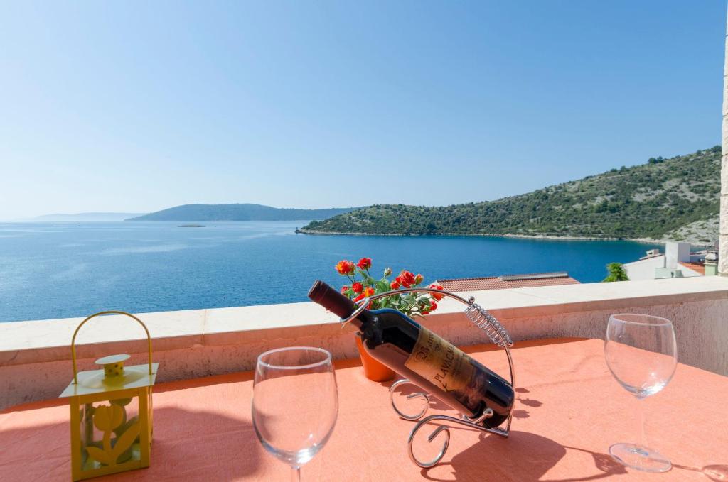 a bottle of wine sitting on a table with glasses at Apartments Ante in Vinišće