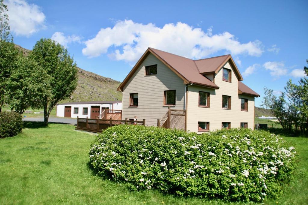 a house with a bush in front of it at Cora´s House & Horses in Ölfus