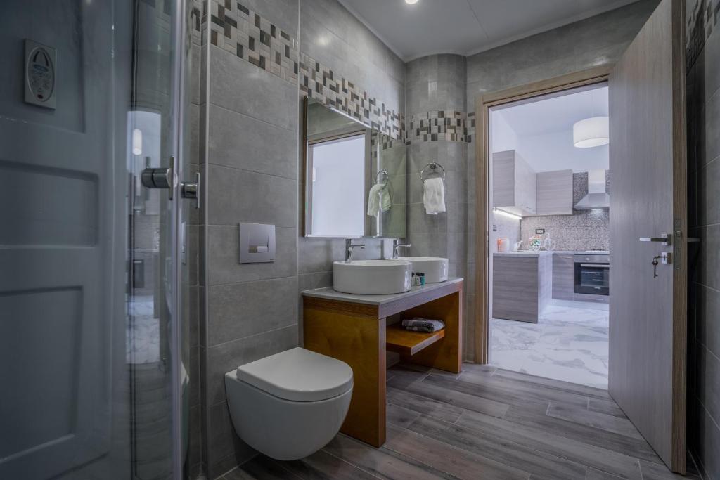 a bathroom with a toilet and a sink and a mirror at Katsaros Luxury Apts 5min walk to beach in Tsilivi