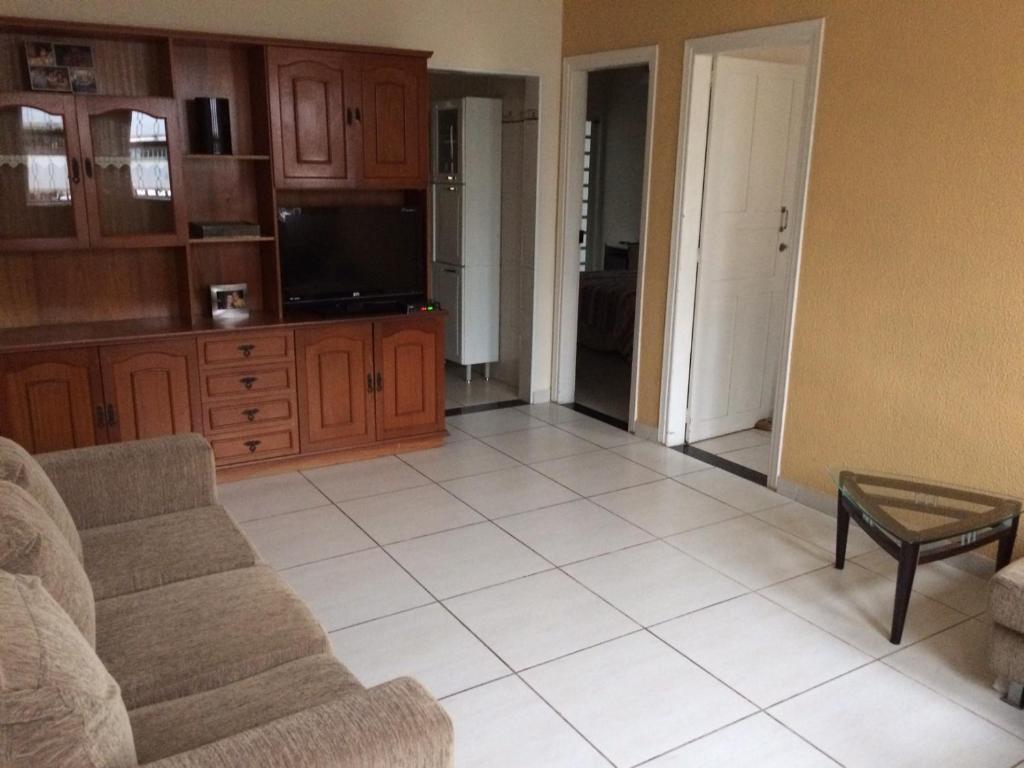 a living room with a couch and a tv at Casa Familiar em Campinas com 2 Quartos, 1 banheiro, 1 vaga para carro in Campinas