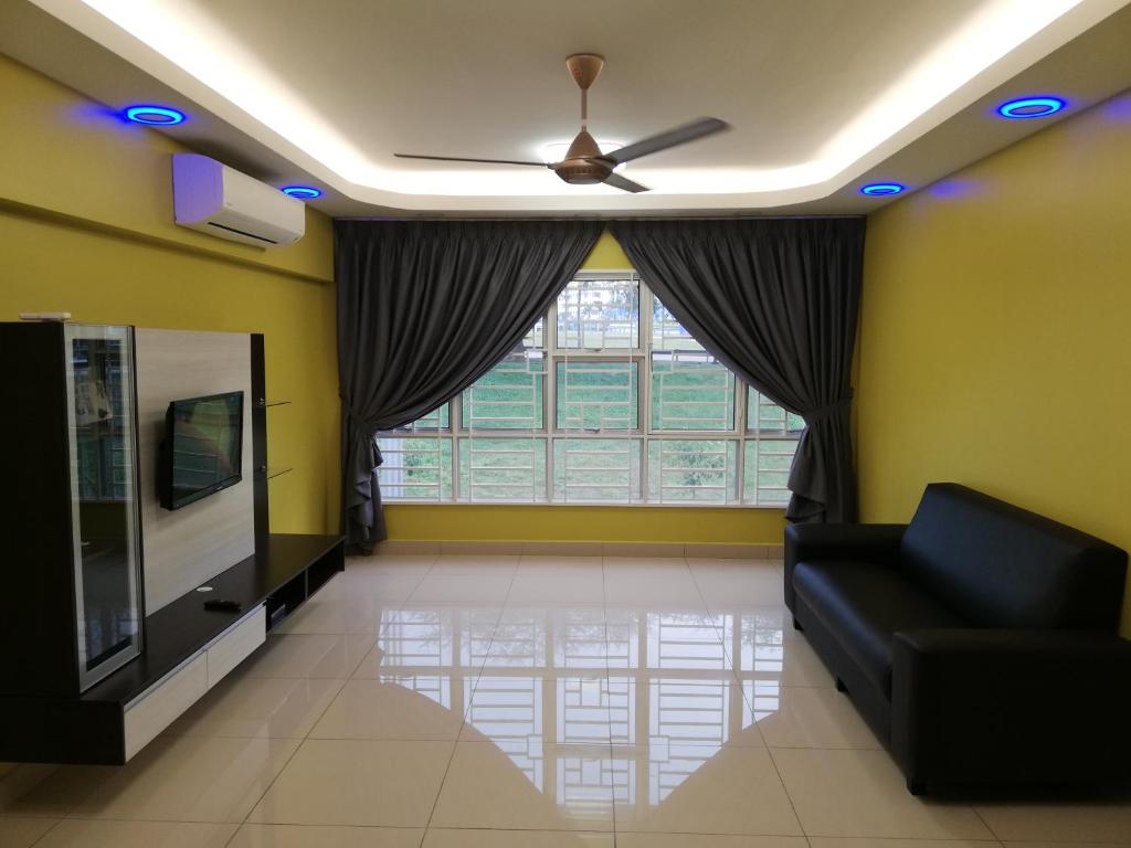 een woonkamer met een bank en een groot raam bij Ae Homestay Putrajaya in Putrajaya