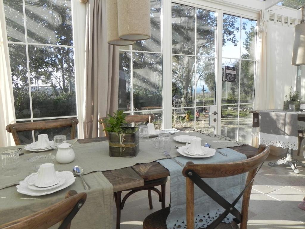 uma sala de jantar com uma mesa e algumas janelas em Locanda di Terramare em Gabbro