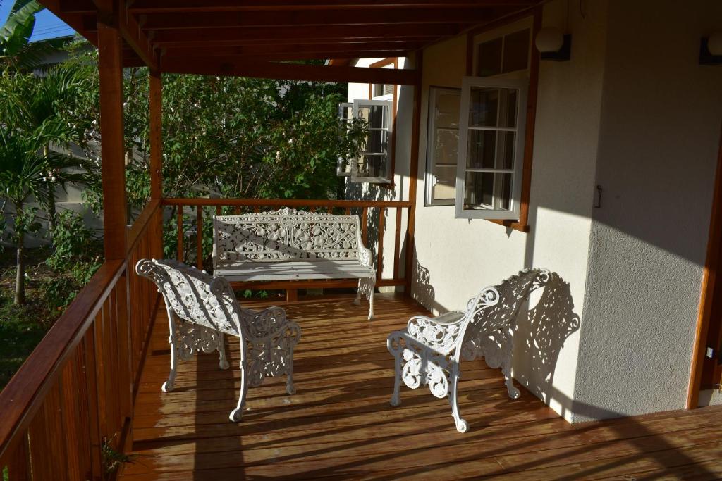 two chairs and a bench on a porch at The Pool House in Saint Philip