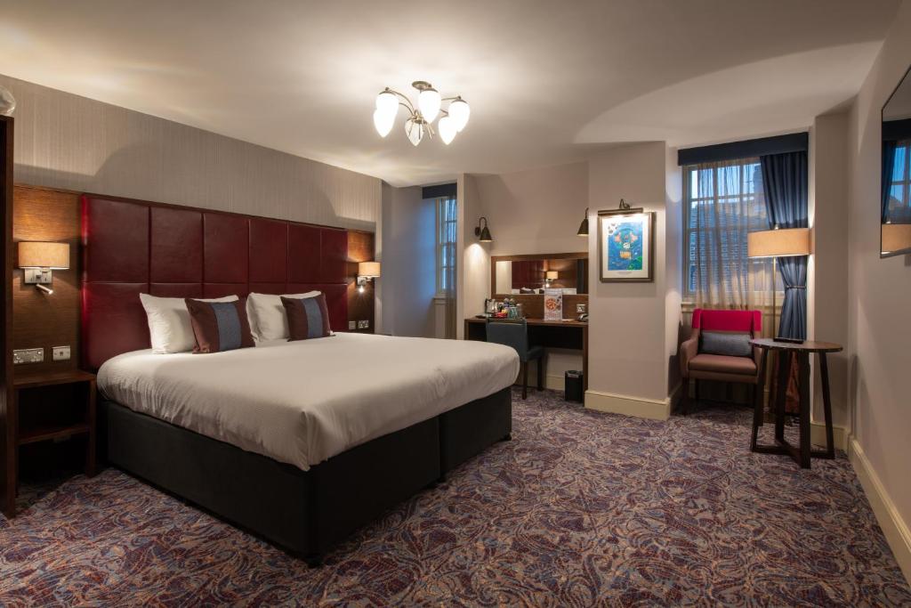 カンタベリーにあるThomas Ingoldsby Wetherspoonのベッドとデスクが備わるホテルルームです。
