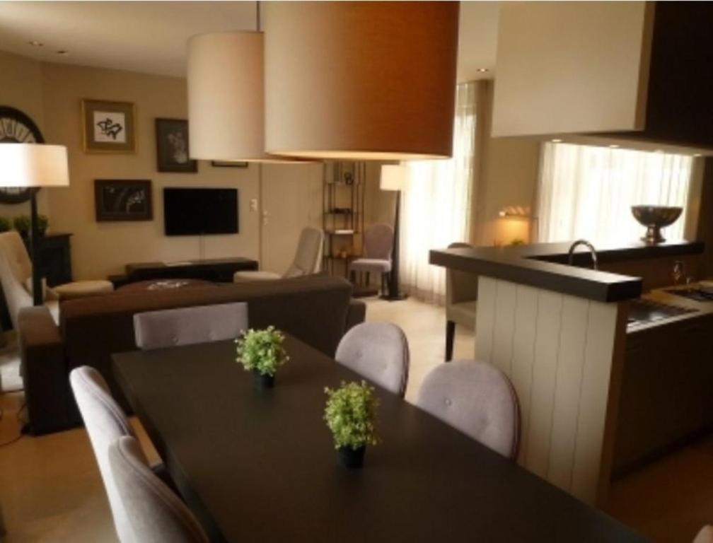 sala de estar con mesas y sillas y cocina en Au Charme des Marais, en Bourges